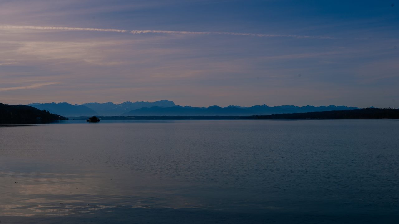 Blick über den Starnberger See auf die Alpen in der Abenddämmerung